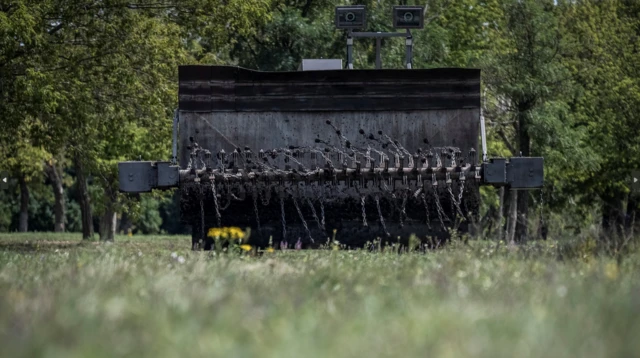 A demining device, mounted on an excavator, is tested near Kryvyi Rih, Ukraine, on 12 August 2023