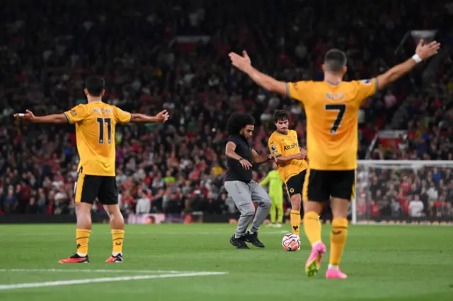 A pitch invader disrupts the game.