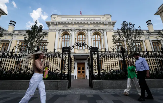 People walk past the Bank of Russia (Central Bank of Russian Federation) headquarters in Moscow