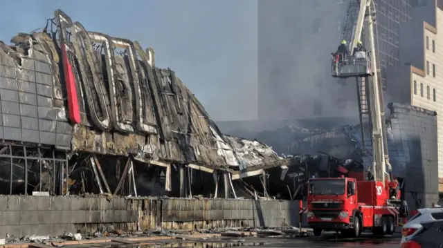 Street-level view of Ukrainian rescuers working at the scene where rocket debris fell on a supermarket