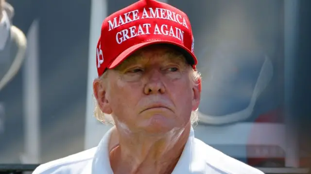 Donald Trump wearing a red hat.