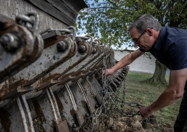 A man holding the front of the demining device near Kryvyi Rih, Ukraine, on 12 August 2023