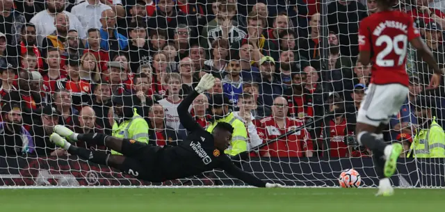 Onana watches the ball fly wide of his left hand post.