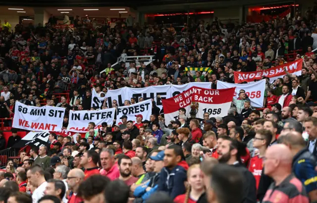 Fans continue to display protest banners at their seats in Old Trafford.