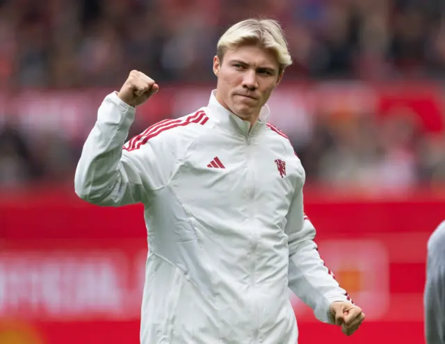 Hojlund fist pumps to the Stretford End as he is unveiled on the pitch.