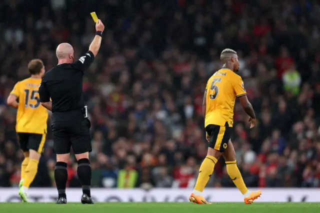 Lemina walks away as he is shown yellow card.