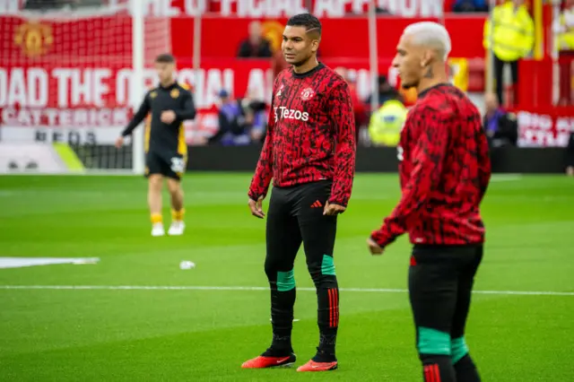 Casemiro and Antony warm up on the pitch.