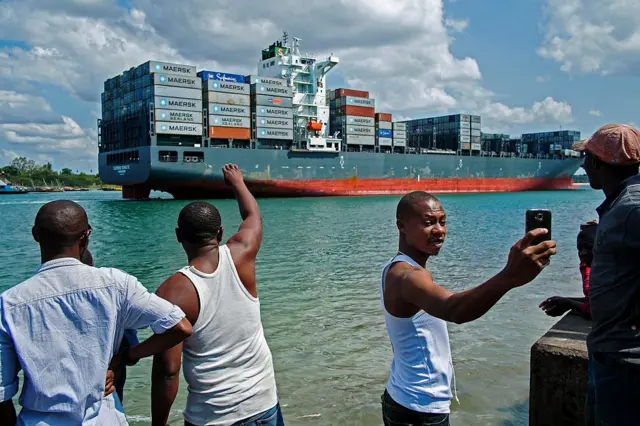 Fishermen watch the Singapore-flagged container ship Clemens Schulte as it arrives in Dar es Salaam, Tanzania on August 27, 2015.