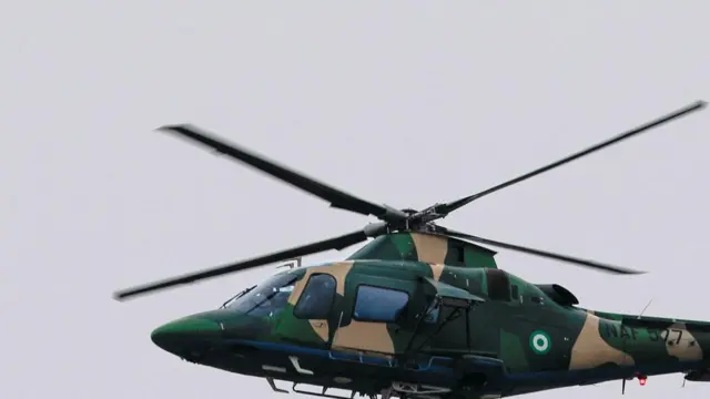 A Nigerian military helicopter carries a Nigerian flag during the swearing-in ceremony of Nigeria's President Bola Tinubu in Abuja, Nigeria May 29, 2023.