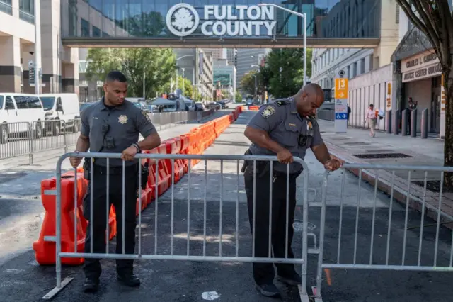 Officers set up security barriers after the Fulton County Sheriff ordered roads to be closed as officials tighten security around the Lewis R. Slaton Courthouse, as the city prepares for a possible criminal indictment of former U.S. President Donald Trump