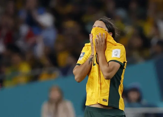 Sam Kerr covers her face with her shirt.