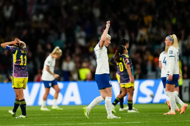 England players throw their hands up in the air, Colombia players sink to the floor.