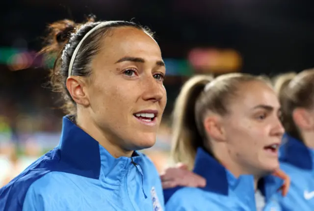 Lucy Bronze and teammates sing the national anthem.