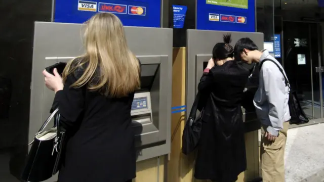 People using cash point machines to withdraw money