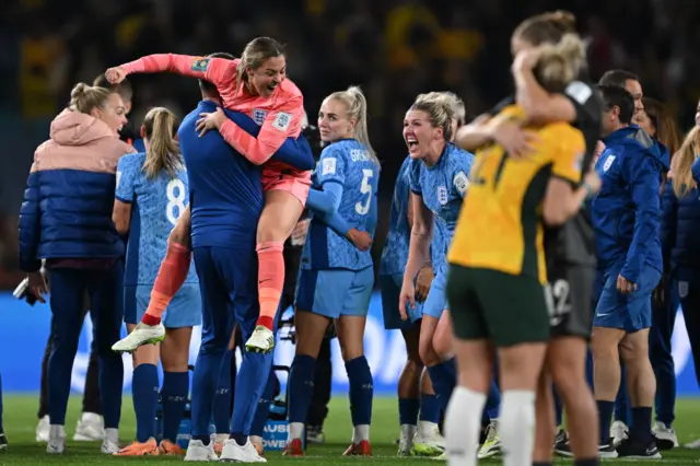 England players celebrater as Matildas players commiserate in the foreground.