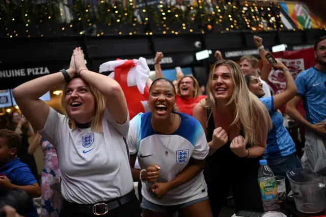 England fans celebrate the victory of England as they watch a screen showing the Women's World Cup semi-final football match between Australia and England, at Boxpark Wembley