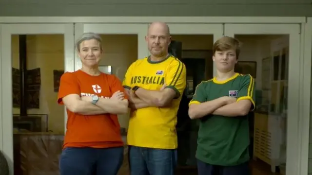 Kate Grant stands alongside her husband and son in different replica shirts.