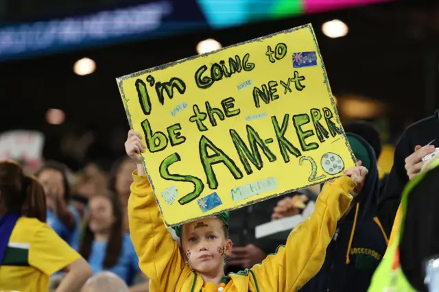 A young fan holds up a sign saying she will be the next Sam Kerr.