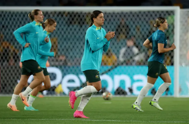 Sam Kerr applauds the fans as she begins the warm up with teammates.