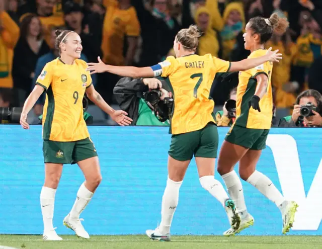 Catley, Foord and Fowler celebrate an Australia goal with the fans.