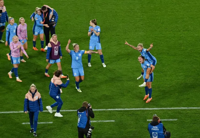 England players celebrate on the pitch at full time after reaching the final.