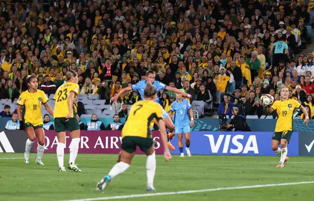 Ella Toone flies into the air after unleashing a powerful shot towards goal - australia defenders watch helpless.