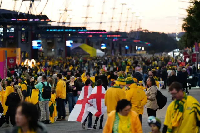 England fans draped in flags walk through a sea of Asutralua fans.