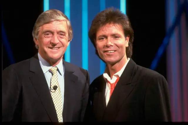 Television presenter Michael Parkinson (L) and pop singer Cliff Richard on the set of chat show Parkinson One To One, circa June 1988