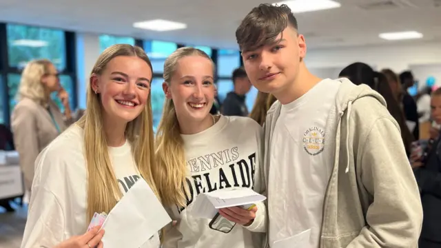 Students Charlotte, Holly and Will smile with their results