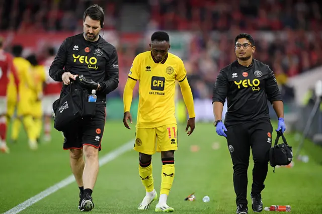 Serge Traore walks down the sideline injured