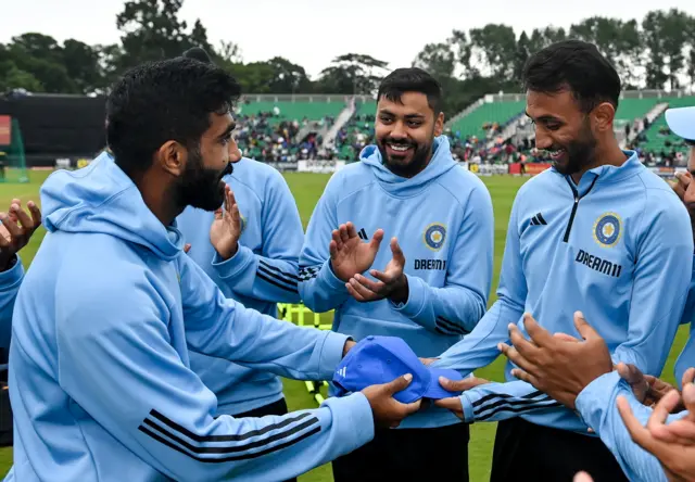 Prasidh Krishna of India (right) is presented with his debut cap by captain Jasprit Bumrah