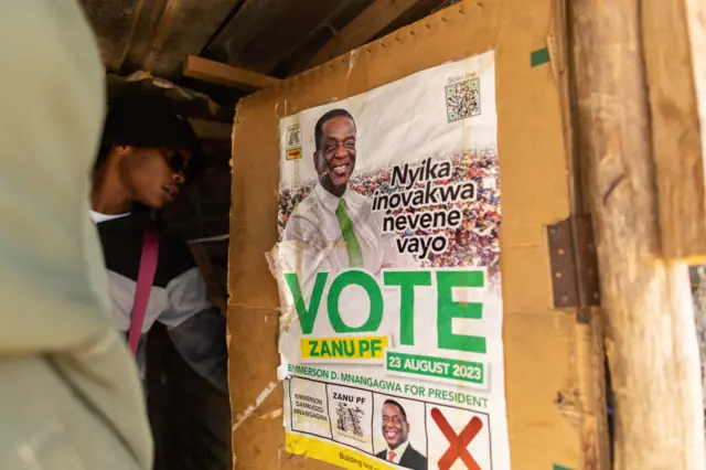 A poster of President Emmerson Mnangagwa is displayed on the door of a barbershop during Zimbabwe's 2023 general election