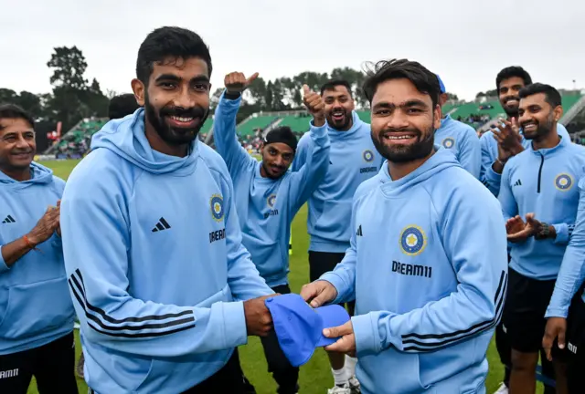 Rinku Singh of India (right) is presented with his debut cap by captain Jasprit Bumrah