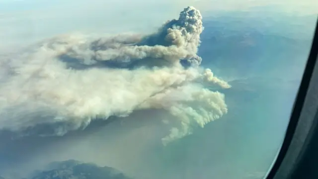 A huge plume of smoke seen from a plane window