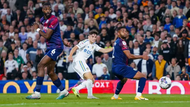 Dan James (centre) takes a shot for Leeds against West Brom