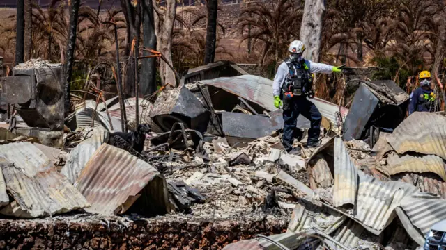 A rescue team search through rubble in Lahaina