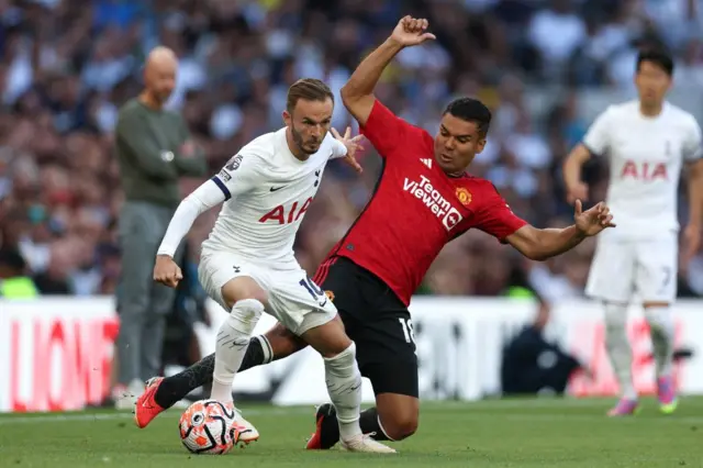 Maddison holds off Casemiro in midfield.