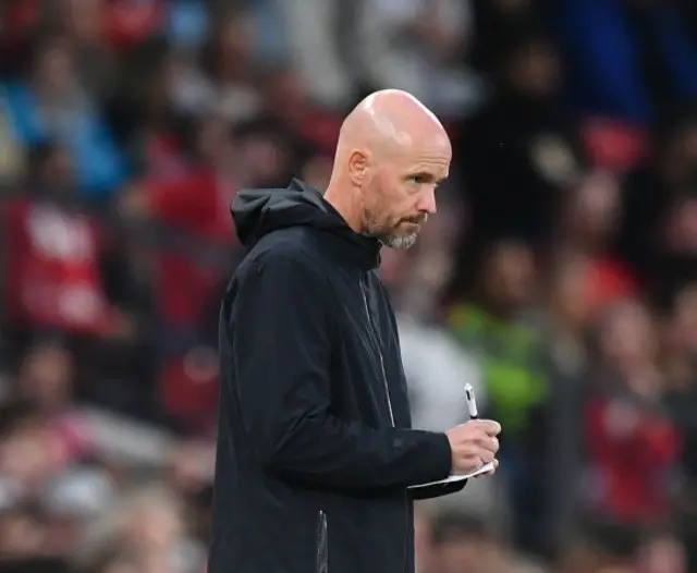 Erik ten Hag makes notes with a four-way pen.