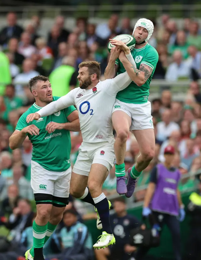 Mack Hansen of Ireland catches the ball despite being challenged by Elliot Daly