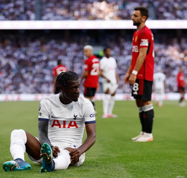 Bissouma sits on the floor to pull up his socks after being fouled.