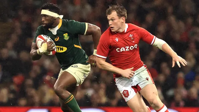 Siya Kolisi carries the ball past Nick Tompkins