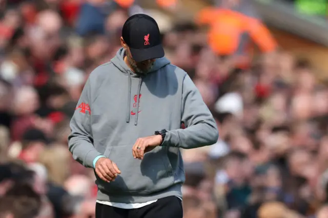 Jurgen Klopp checks his watch on the touchline.