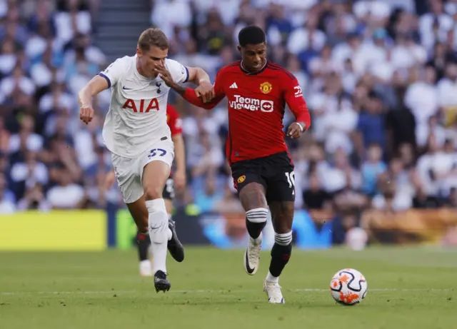 Rashford holds off the challenge of Van de Ven.