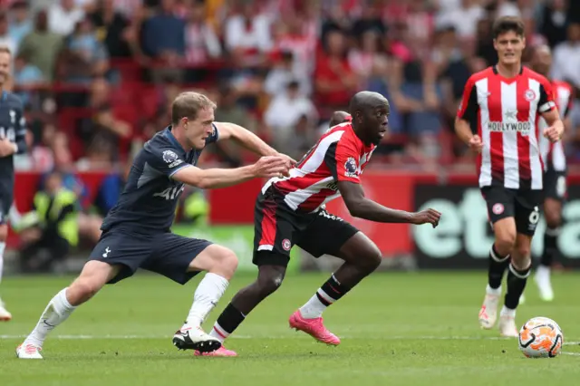 Yoane Wissa breaks away from Oliver Skipp in midfield.