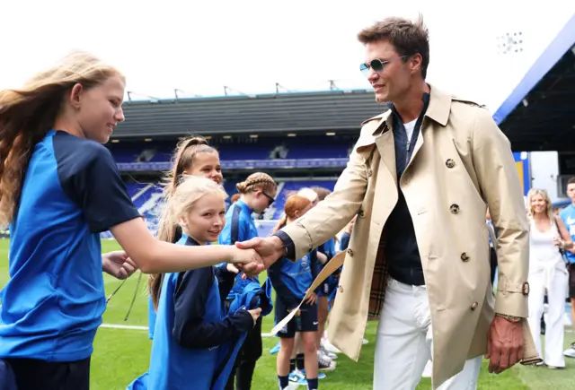 Tom Brady shakes hands with one of the young ballgirls