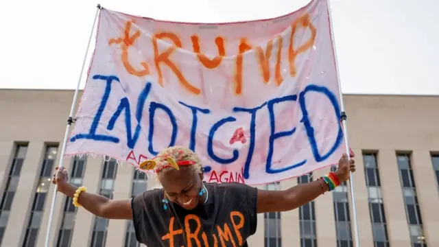 Nadine Seiler holds a banner in front of the federal courthouse where former U.S. President and Republican presidential candidate Donald Trump is expected later this week to answer charges after a grand jury returned an indictment of Trump in the special counsel's investigation of efforts to overturn his 2020 election defeat In Washington, U.S. August 1, 2023.