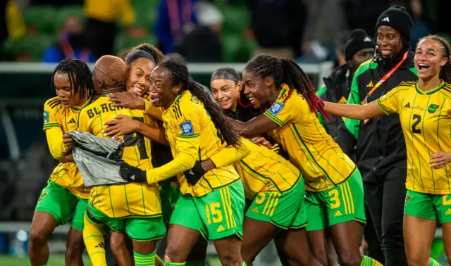 Jamaica's players celebrate qualifying for the last 16