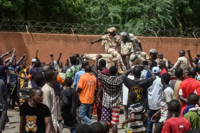 Protesters cheer Nigerien troops as they gather in front of the French Embassy in Niamey during a demonstration that followed a rally in support of Niger's junta in Niamey on July 30, 2023.