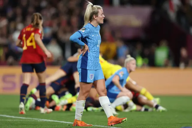 Lauren Hemp stands in disbelief as the Spain players celebrate behind her.