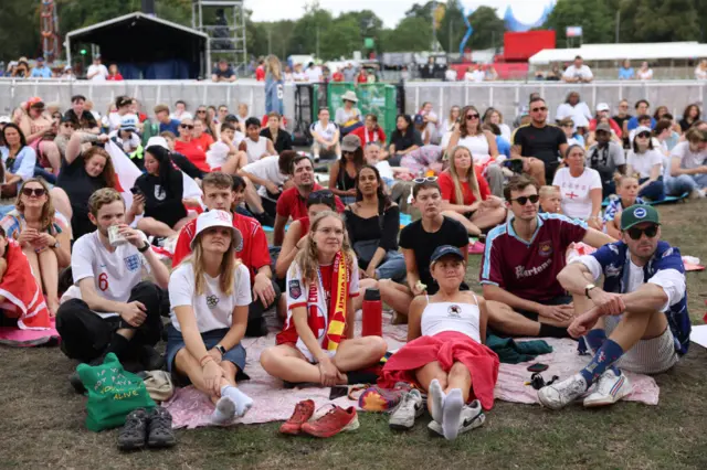 Fans gather at an official watch party in half and half scarves and England memorabilia.